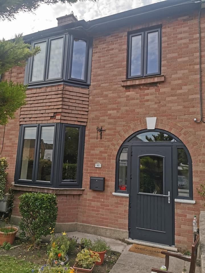 Red-brick semi-detached house with a new anthracite grey bow window and an arched anthracite composite door with sidelight