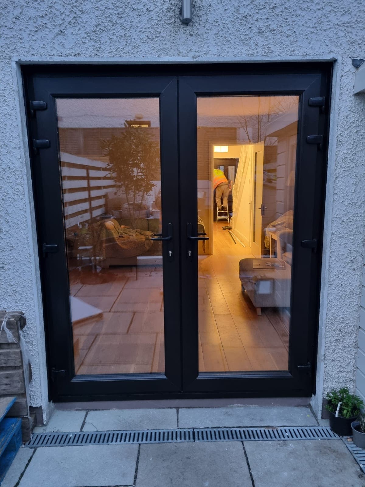 Black aluminium French doors viewed from inside in the evening