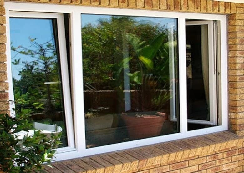 White uPVC triple tilt and turn window, opened, with plants on the patio outside