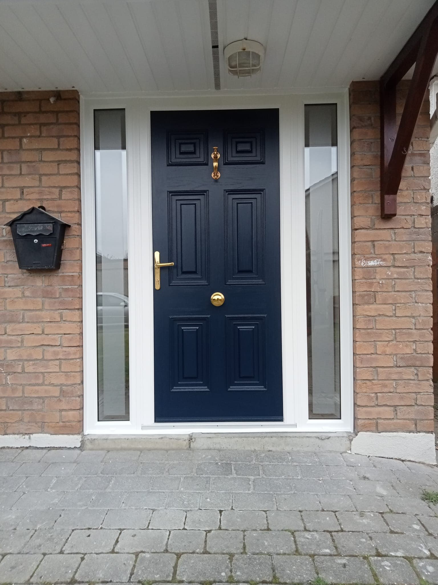 Navy Georgian-style six-panel composite front door with brass hardware and sidelights