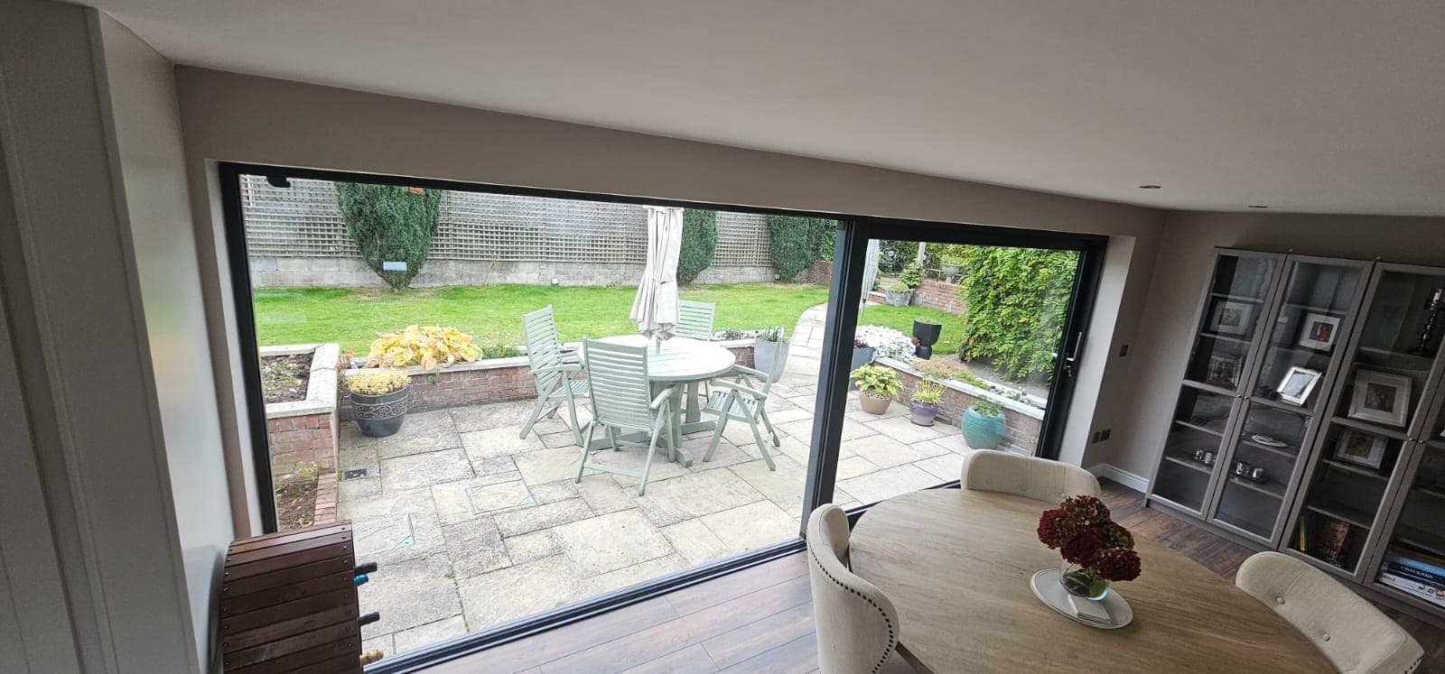 Dining area with a black aluminium sliding door open to the patio