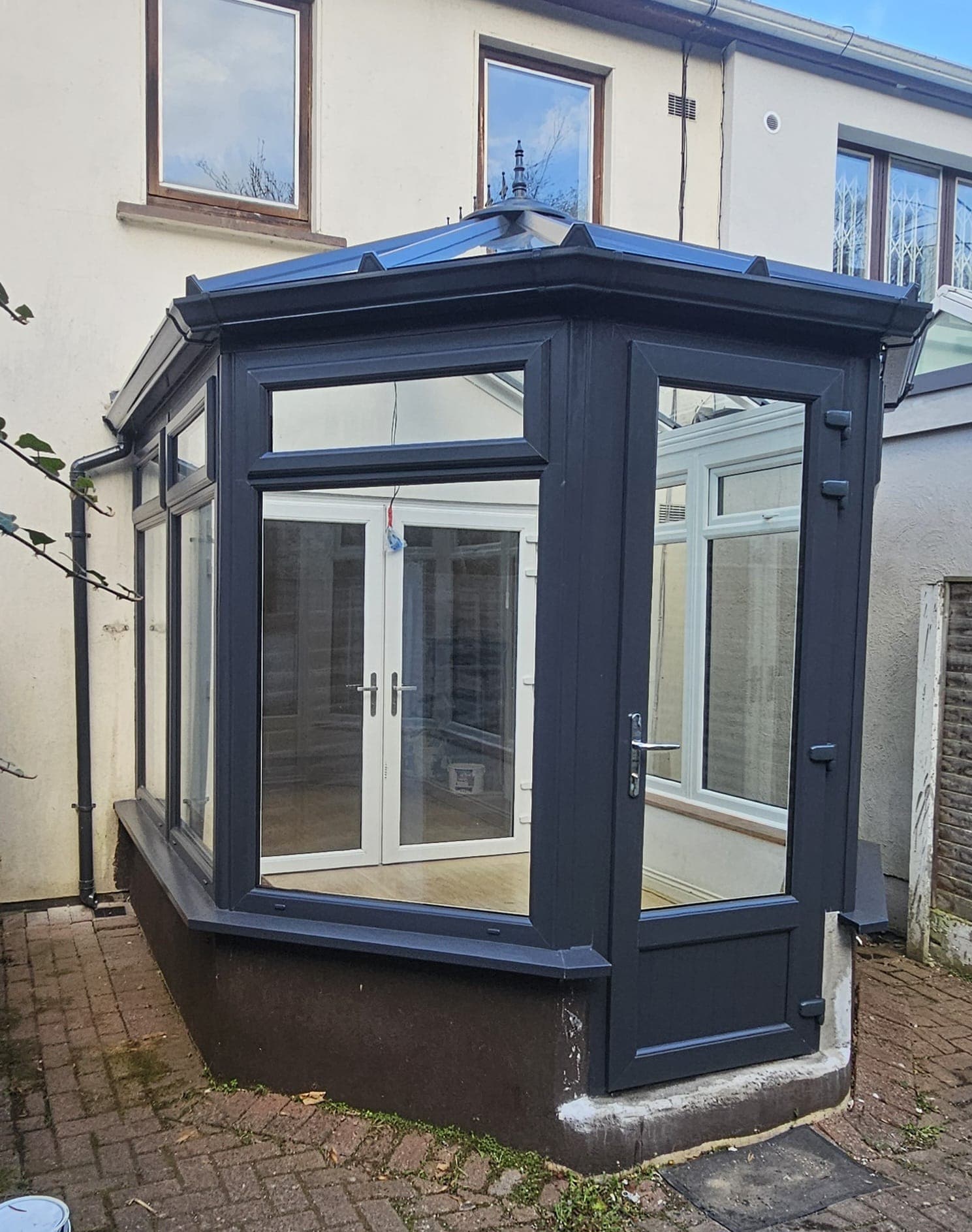 Anthracite grey orangery extension with French doors visible inside